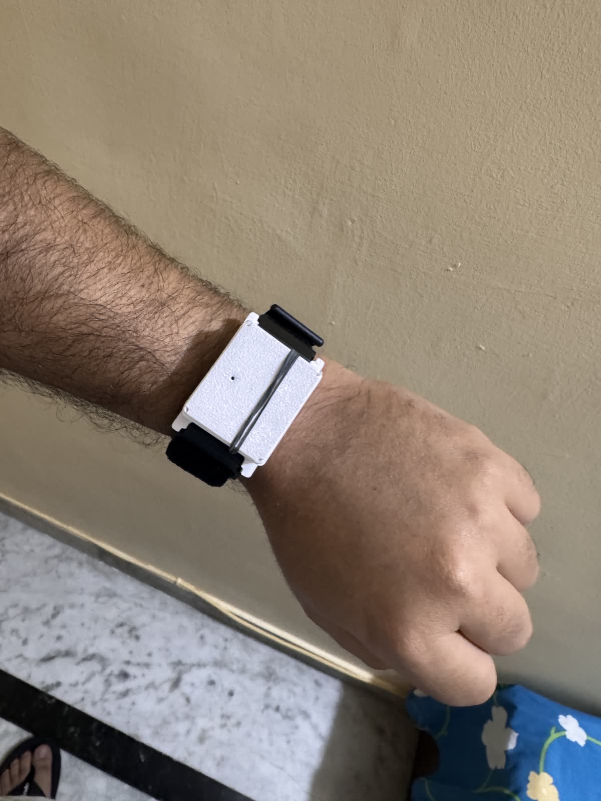 Top view of the white Keepshake prototype being worn on a wrist